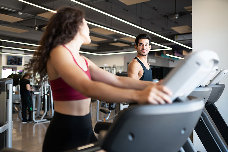 Frau und Mann auf Laufband in Fitnessstudio