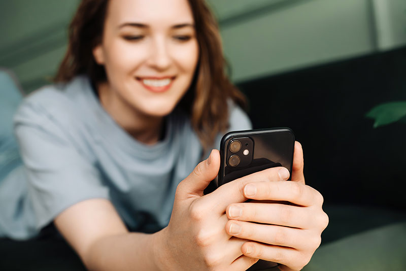 Frau liest eine Nachricht auf ihrem Smartphone