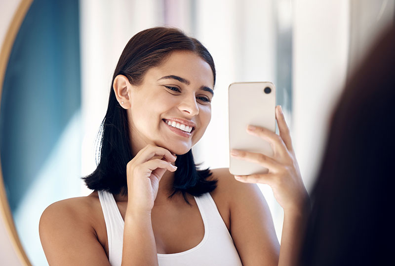 Junge Frau macht ein Selfie im Spiegel