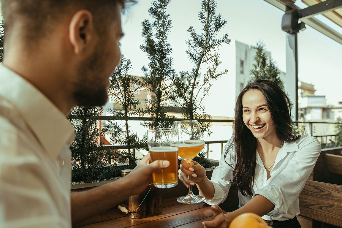 Frau stößt mit Mann in Restaurant an