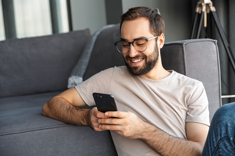 Glücklicher junger Mann am Handy