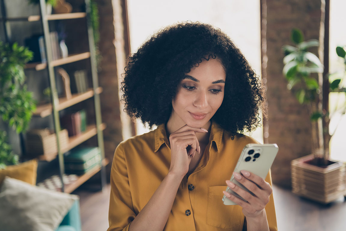 Frau lächelt charmant in ihr Handy