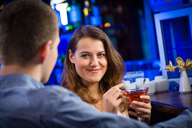 Frau nimmt einen Drink in einer Bar