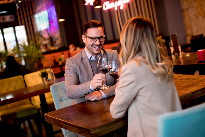 Paar stößt beim Abendessen mit Rotwein an